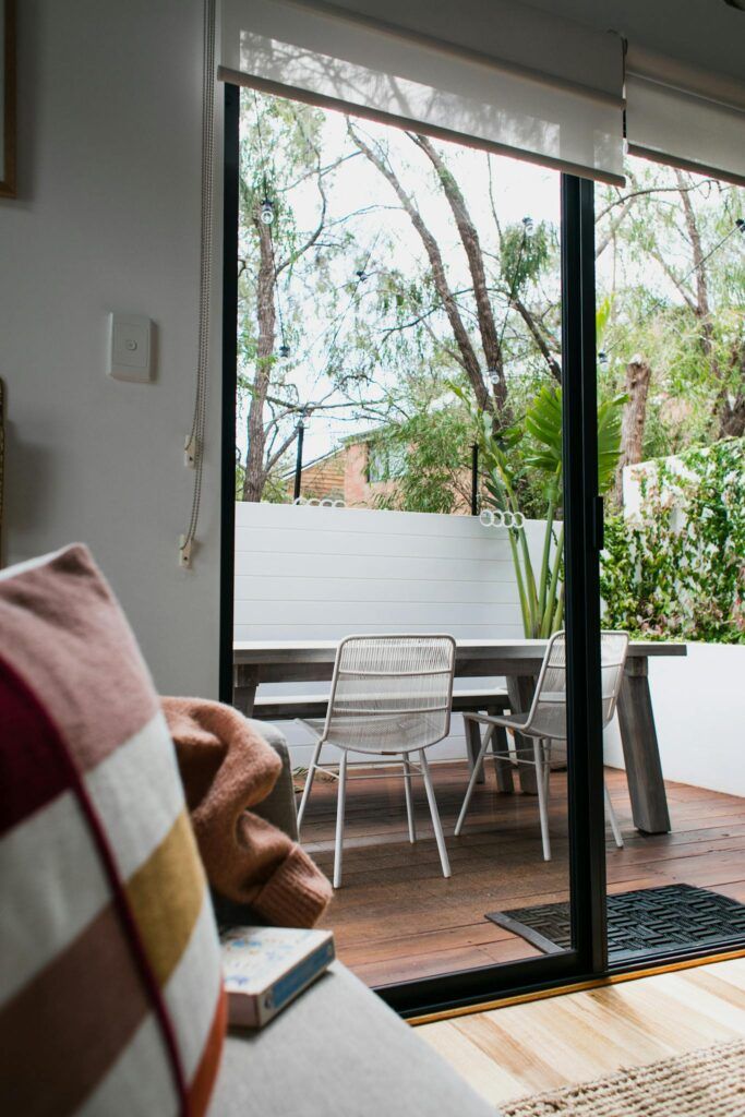 Contemporary interior of house with pillow and book near terrace with chairs and table